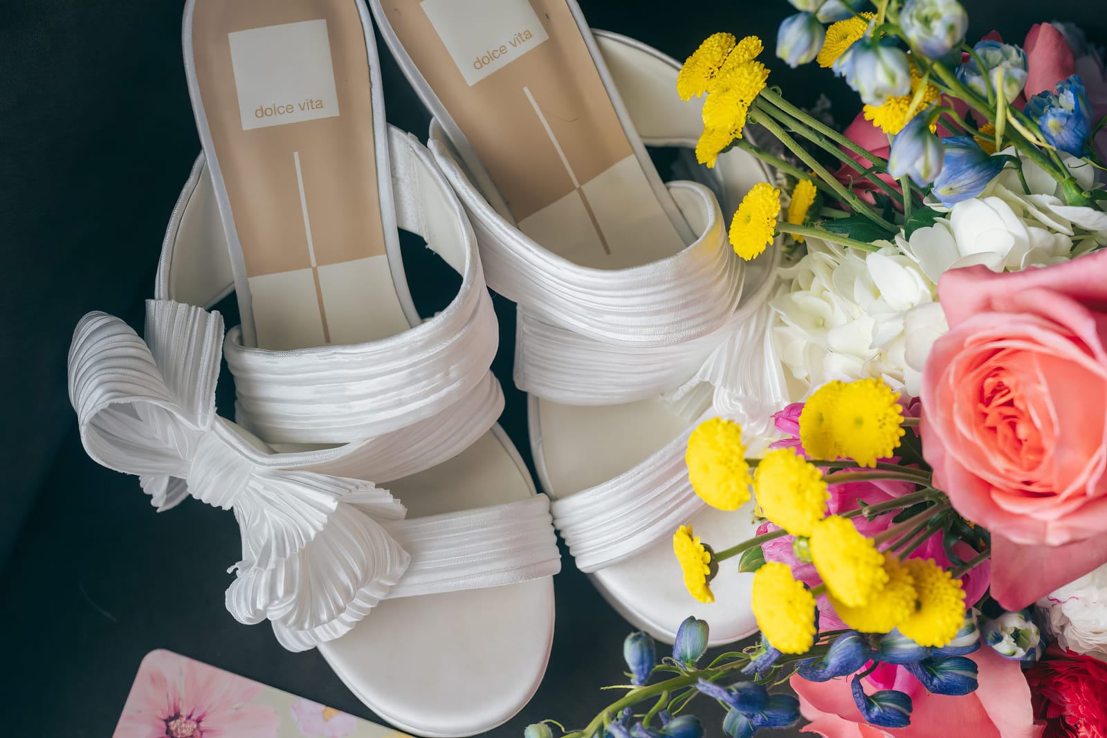 Bridal shoes next to a colorful bouquet